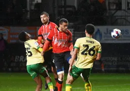 Carlton Morris heads the ball past Zak Vyner