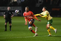 Carlton Morris moves the ball away from Cameron Pring