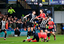 Tom Lockyer goes up for a header as Allan Campbell waits for the ball to drop