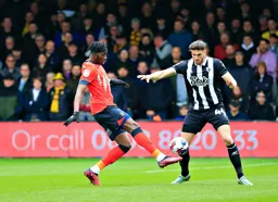 Elijah Adebayo controls the ball in front of Wesley Hoedt