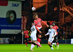 Carlton Morris is held as he attempts to head the ball