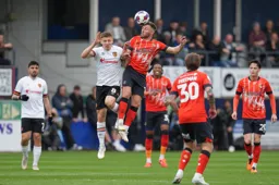 Jordan Clark gets his head to the ball in front of Greg Docherty