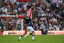 Luke Berry chases the ball as Pierre Ekwah misjudges the flight