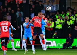 Carlton Morris heads the ball on