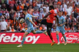 Elijah Adebayo juggles the ball past Luke McNally
