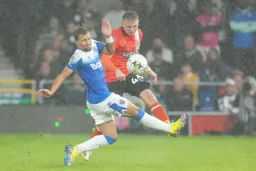 Alfie Doughty fighting the Gillingham defender and the rain
