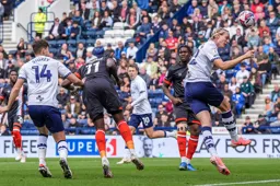 Elijah Adebayo stoops to send a header towards goal