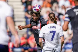 Teden Mengi heads the ball clear