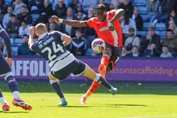 Elijah Adebayo lifts the ball over Casper De Norre
