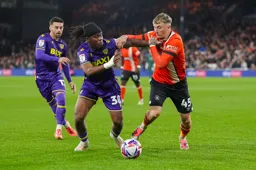 Alfie Doughty grapples for the ball with former Hatter Peter Kioso