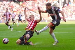 Jordan Clark manages to get a shot at goal despie Alfie Gilchrist`s best efforts