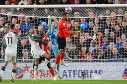 Thomas Kaminski and Carlton Morris combine to clear the ball