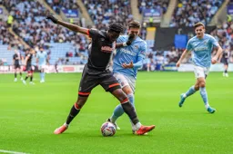 Elijah Adebayo hands off a would be tackle