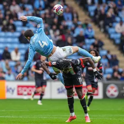 Elijah Adebayo takes evasive action as Bobby Thomas flies over the top