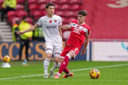 Daiki Hashioka slips the ball past Hayden Hackney