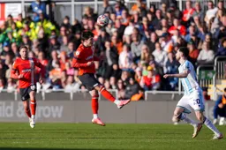 Liam Walsh heads the ball on