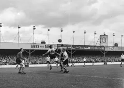 Reg Pearce heads the ball clear